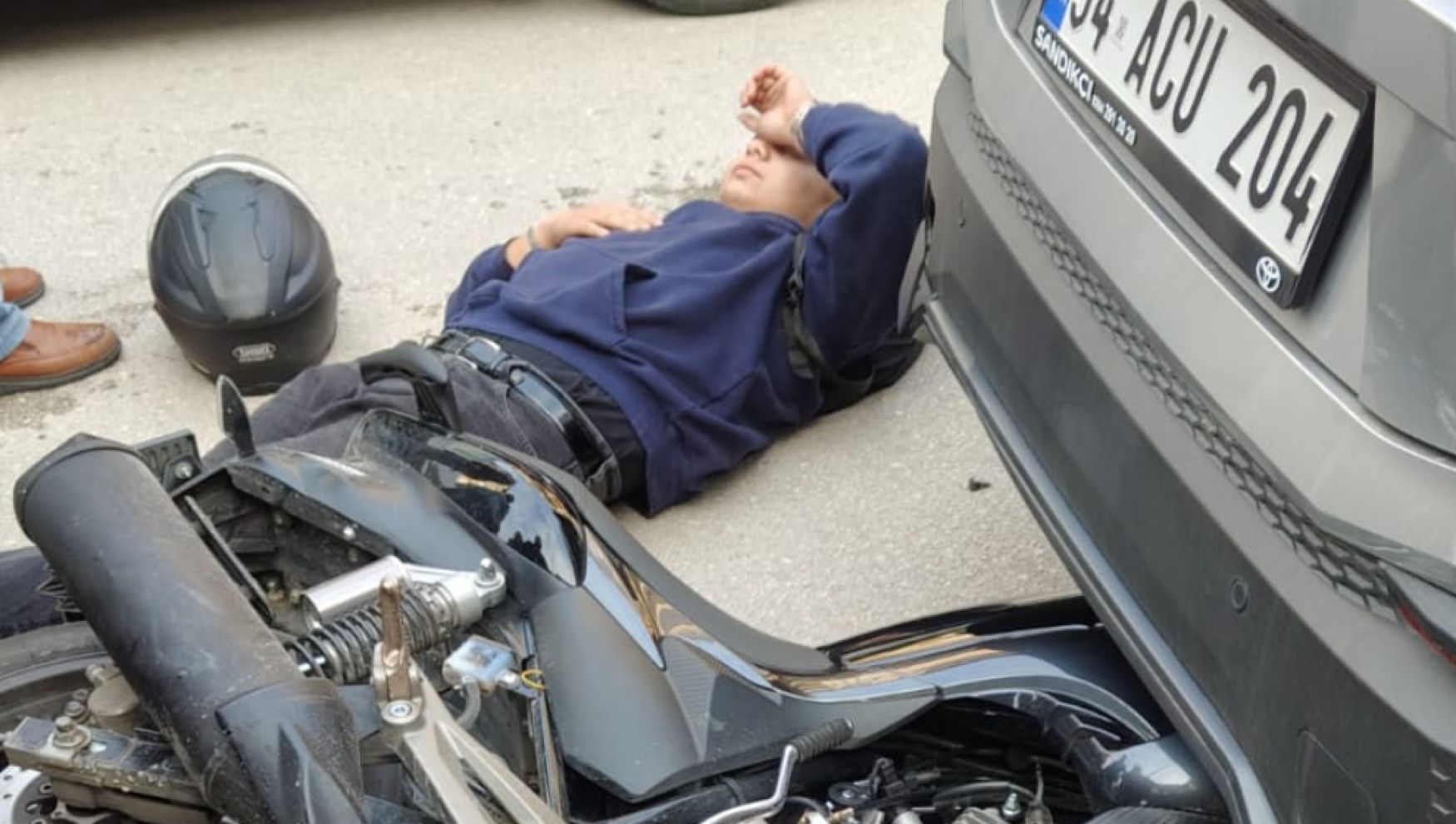 Motosiklet park halindeki otomobilin altına girdi: Sürücü yaralandı